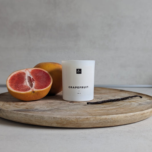 Volledig shot van de Grapefruit & Vanille geurkaars van HJEV, gepresenteerd in een levendige en kleurrijke verpakking. De kaars verspreidt een verfrissende en energieke geur, waarbij de sprankelende aroma's van grapefruit perfect samengaan met de warme en zoete tonen van vanille, waardoor een opwekkende en stimulerende sfeer in huis wordt gecreëerd.