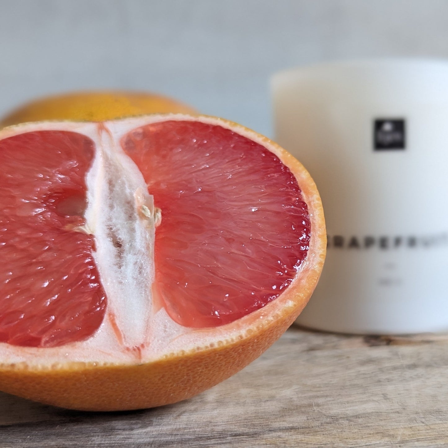 Een close-upafbeelding van de Grapefruit geurkaars van HJEV, gepresenteerd in een levendige en kleurrijke verpakking. De kaars verspreidt een verfrissende en energieke geur, geïnspireerd door de sappige en sprankelende aroma's van grapefruit, waardoor een opwekkende en stimulerende sfeer in huis wordt gecreëerd.